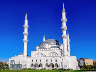 Fototapeta na wymiar Amazing white Melike Hatun Mosque with four minarets in Ankara, Turkey. Beautiful eclectic building of a Muslim temple in neo-classical Ottoman architecture style a tourist attraction