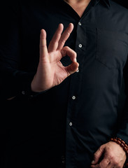 man in a black shirt shows with his hand the gian mudra