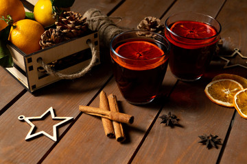 Christmas mulled red wine with spices and fruits on a wooden rustic table. Traditional hot drink at Christmas time