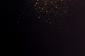 Christmas Gold glitter on black background. Holiday abstract