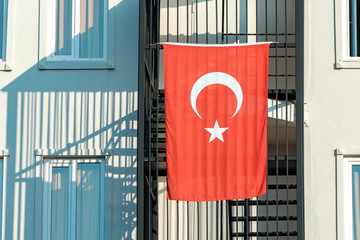 flag of Turkey on the outer flight of stairs on the background of a light wall