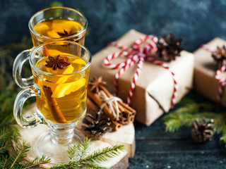 Traditional Christmas hot drink on the table with Christmas tree branches and gifts