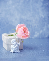 angel and roses and gift box on blue background. beautiful scene of love and tenderness, background...