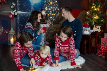 Fototapeta na wymiar Happy smiling family, mom, dad and three boys, having family portrait at home for Christmas