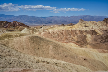 Fototapeta na wymiar Zabriskie Point, surrounded by a maze of wildly eroded and vibrantly colored badlands in Death Valley, USA
