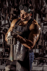 Fototapeta na wymiar confident forger in leather uniform isolated in workshop. special equipment. strength and power concept. muscular body