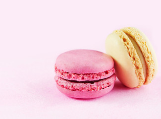 Raspberry and lemon flavored French macarons, almond flour cookies on pink background
