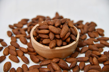 Roasted almonds in wooden bowl on white background. Close up photo of Roasted almonds.