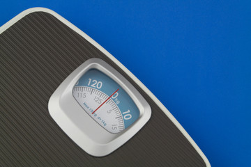 Scale on blue background with space for text. Loose weight and overweight concept.