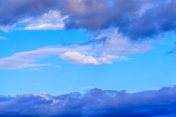 A medley of colorful clouds isolated against pastel blue skies