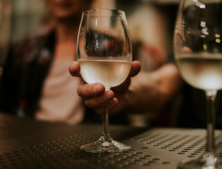 Closeup of a man's hand drinking wine with collegues