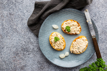 Sandwiches with salmon pate and baguette, fish bruschetta, top view. Rustic homemade Italian cuisine.