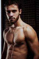 Fototapeta na wymiar portrait of young confident caucasian bearded man looking at camera after shower, muscular body