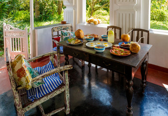 wooden table is covered with healthy variety of natural food, banana porridge, scrambled eggs, omelet with vegetables, coconut, dragon's eye