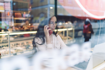 Business woman using laptop and talking on phone
