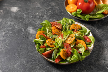 Healthy vegetable salad from fresh vegetables of tomatoes, cucumbers, onions, spinach, lettuce on a plate. Diet menu. View from above.