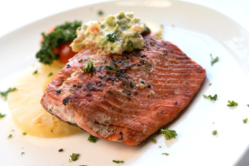 Caramelized Pineapple salmon fillet with celery served on a white plate