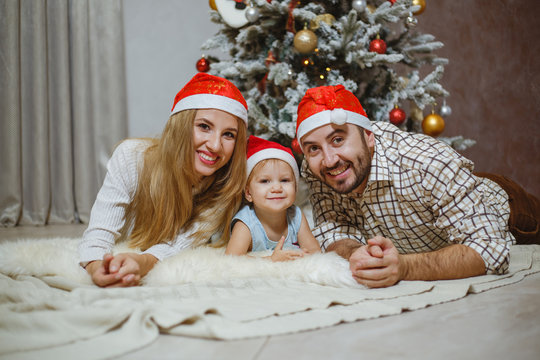 Beautiful family pictures near Christmas tree at home.