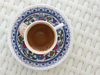 Top view of Turkish coffee in traditional coffee cup with Turkish delight on white table