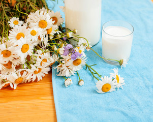Obraz na płótnie Canvas Simply stylish wooden kitchen with bottle of milk and glass on table, summer flowers camomile, healthy foog moring concept close up