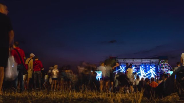 People on a live open air music show, concert, blur, time lapse. night summer time. light and fast motion
