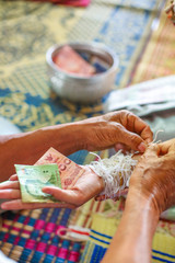 Guests tied wrist and give money for the groom and bride in Thai wedding ceremony