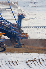 Large excavator on surface mine in winter conditions.