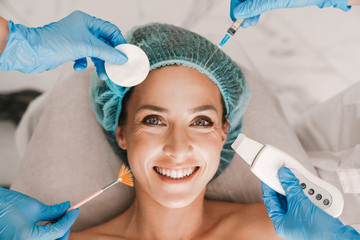 Photo closeup of smiling caucasian woman getting cosmetic procedure