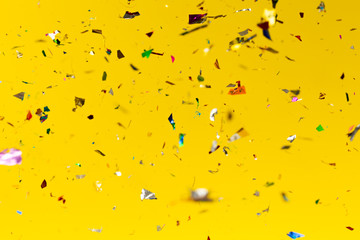 Colourful glitter drops on yellow background.