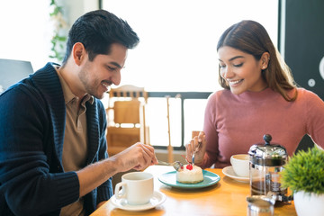 Lovers Enjoying Dessert Together At Cafe