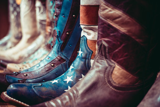 Cowboys boots on a shelf in a store with USA flag
