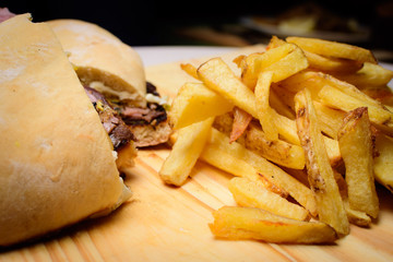 Hamburguesa y papas fritas en tabla de madera