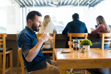 Man Having Coffee While Thinking At Cafe