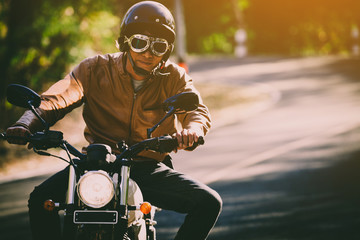 filter and grain photo ; man riding motorbike on a road in freedom lifestyle at vacation time	