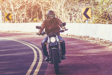 filter and grain photo ; man riding motorbike on a road in freedom lifestyle at vacation time	