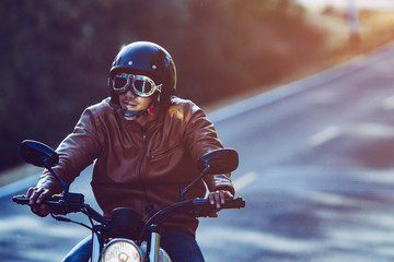 filter and grain photo ; man riding motorbike on a road in freedom lifestyle at vacation time	