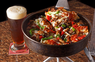 Deep dish supreme pizza and beer