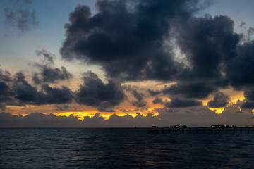 Sunset background and sun beam on the open sea with beautiful clouds.