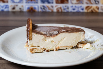 pedaço de torta holandesa gelada em pires colorido sobre mesa de madeira