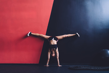 Fit lady exercising near wall