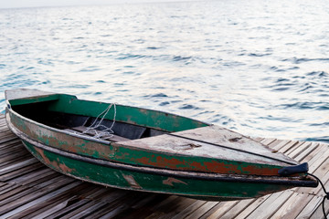 Old wooden boat sitting on the pier overlooking the beautiful Semporna turquoise sea.