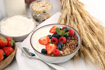 Tasty homemade granola served on table. Healthy breakfast with a bowl of oatmeal with banana, blueberries, strawberries and healthy food for Breakfast