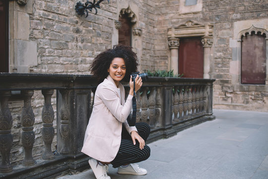 Trendy happy woman holding camera in hand