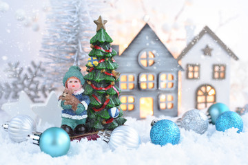 Christmas composition with decorative figure of boy and Christmas tree, festive decorations оn the snow. Christmas or New Year greeting card.