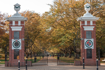 Walking through Queens Park gates on a sunny day