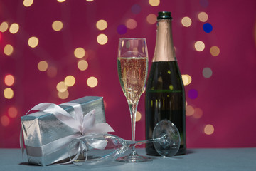 Bubbly glass of champagne with gift box and bottle