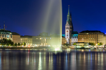 Panoramic view of the Binnenalster lake with fountain and the center of Hamburg at night.