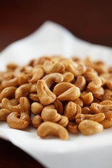 Close-up of cashew nuts in a dish with wood table.