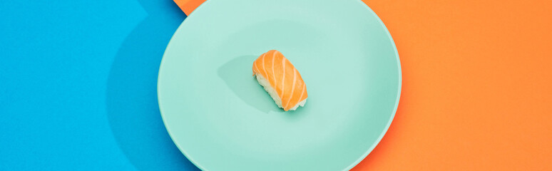 fresh nigiri with salmon on blue and orange surface, panoramic shot