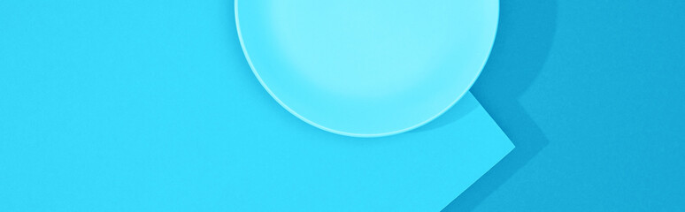 top view of empty plate on colorful blue surface, panoramic shot